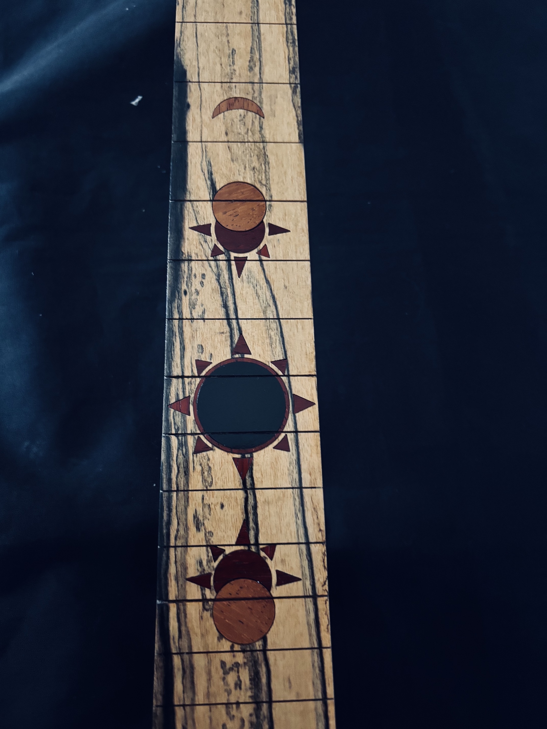 Finished sun and moon inlays on a Pale Moon ebony fingerboard